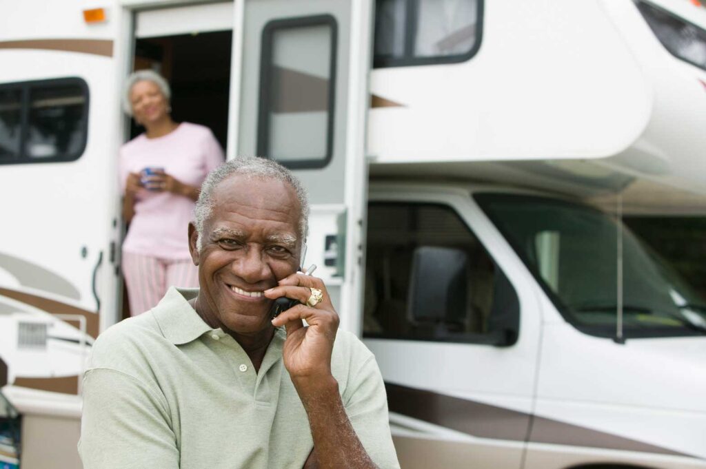 Senior couple outside their caravan