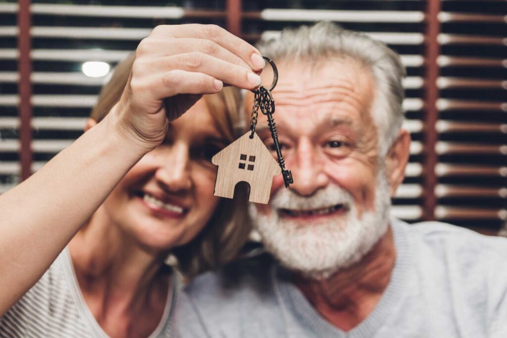 Retirement couple in their homes holding house key after taking A.S.A.G. Equity Release