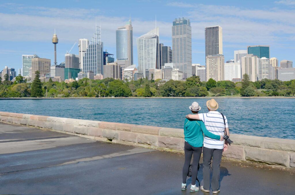 Senior Couple looks at Sydney Central Business District skyline as view from the Royal Botanic Gardens in Sydney New South Wales, Australia after taking A.S.A.G. Equity Release