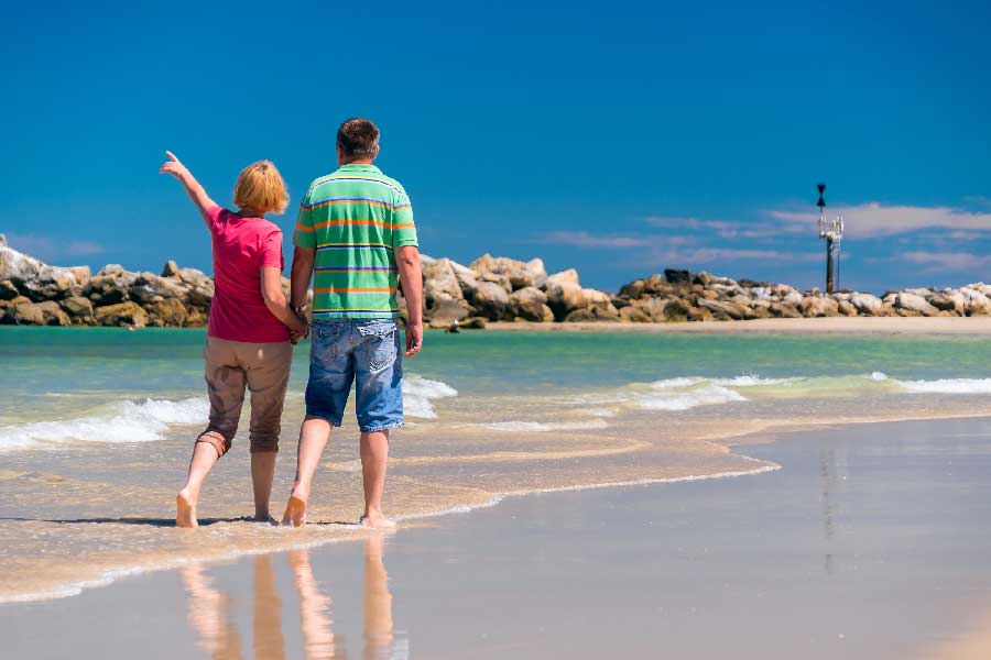 Senior couple walking at a beach in Adelaide, SA holding hands of each other