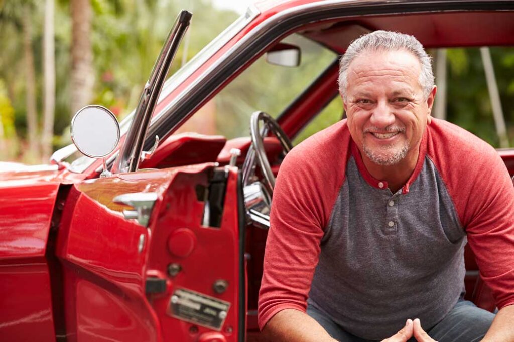 Retired Senior Man Sitting In Restored Classic Car