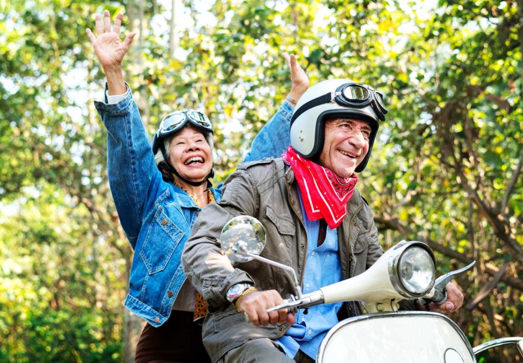 Senior couple riding a classic scooter