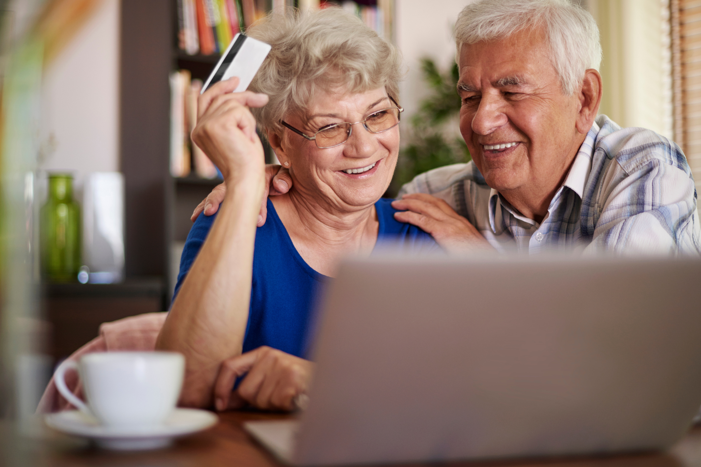 Older Australian couple using a laptop to browse Black Friday deals online, planning smart shopping choices for retirement savings.